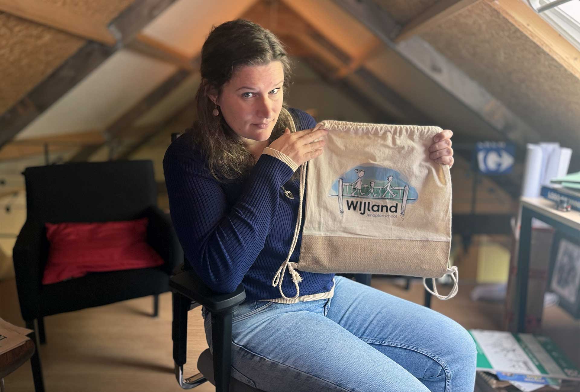 Vita houdt de tas met het logo omhoog